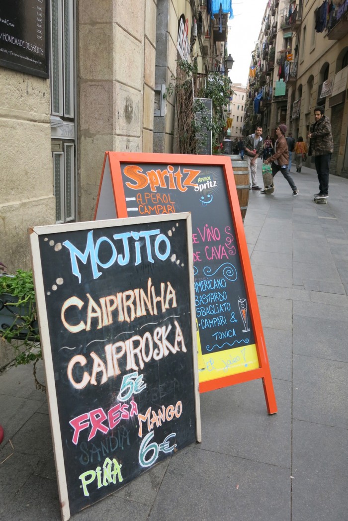 Värikkäät katumainokset kutsuvat drinkille tai cocktailille El Ravalissa Barcelonassa